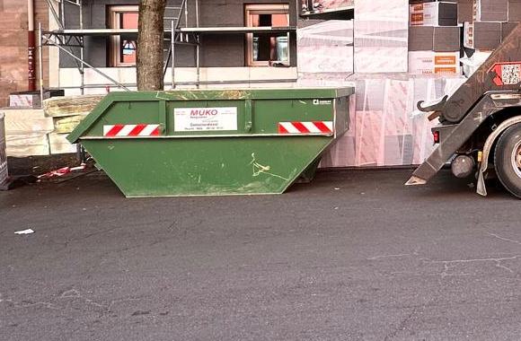 Grüne MÜKO Absetzmulde auf einer Baustelle